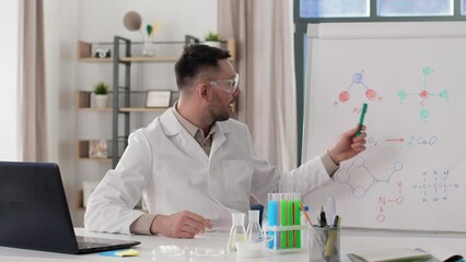 Poster - distance education, school and remote job concept - happy smiling male chemistry teacher with laptop computer having online class and showing molecular model on flip chart at home office