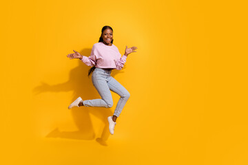 Wall Mural - Full length photo of overjoyed cheerful girl raise arms palms isolated on yellow color background