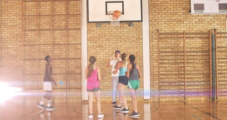 Poster - Animation of light spots over diverse schoolchildren playing basketball at gym