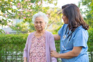 Doctor help and care Asian senior or elderly old lady woman use walker with strong health while walking at park in happy fresh holiday.