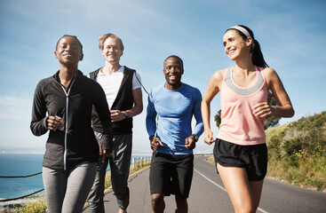 Wall Mural - Good friends make the simple seem magnificent. Shot of a group of people out running together.