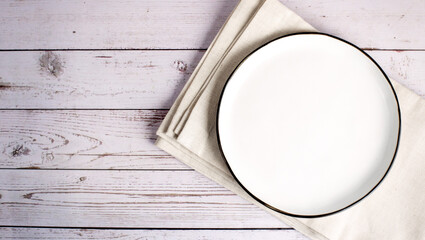 ceramic plate on napkin on white wooden table.Flat lay