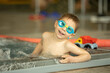 © Tomsickova - Child, taking swimming lessons in a group of children in indoor pool