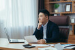 © Liubomir - Serious and pensive Asian businessman, boss, working in a classic office, thinking about a solution