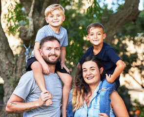 Wall Mural - Prettiest necklace My kids arms. Portrait of a beautiful family with their sons on their shoulders in a park.