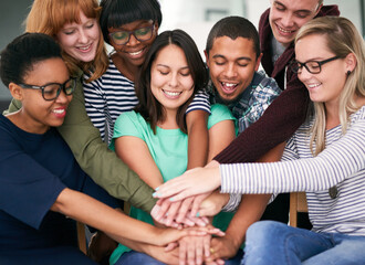 Poster - Huddled around happiness. Shot of a group of people putting their hands together.