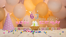 Beautiful Background Happy Birthday Number 63 With Burning Candles, Birthday Candles Pink Letters For Sixty Three Years. Festive Background With Balloons