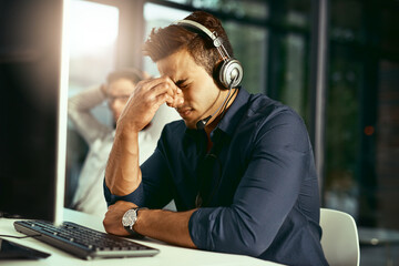Aufkleber - Its been a stressful day at work. Shot of a young call centre agent looking stressed out while working in an office.