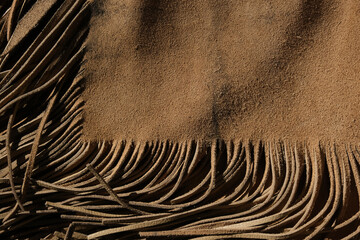 Sticker - Western industry leather background shows armitas leather with fringe.