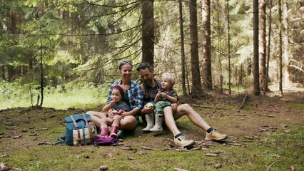 Wall Mural - family with small children having picnic in summer forest .