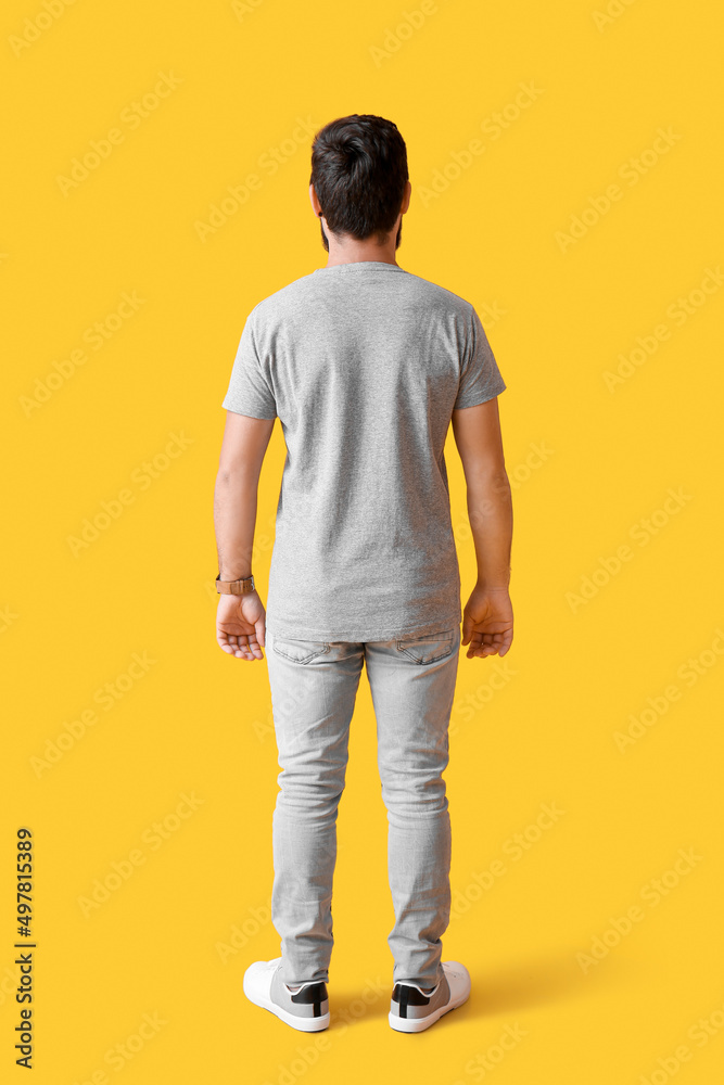 Handsome man in grey t-shirt on yellow background