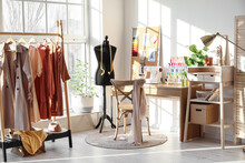 Interior Of Stylish Atelier With Tailor's Workplace, Mannequin And Rack