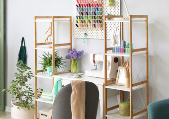 Wall Mural - Interior of stylish atelier with tailor's workplace, shelving units and pegboard