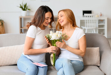 Wall Mural - Young woman greeting her mother for International Women's Day at home