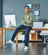 © Katleho Seisa/peopleimages.com - Its the best being your own boss. Portrait of a cheerful young businessman seated on his desk with his arms folded inside of the office during the day.