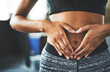 © Delmaine Donson/peopleimages.com - Everyday is core strengthening day. Cropped shot of a fit young woman making a heart shaped gesture over her stomach in a gym.