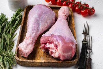 Wall Mural - Fresh turkey legs with ingredients for cooking, on white stone table background