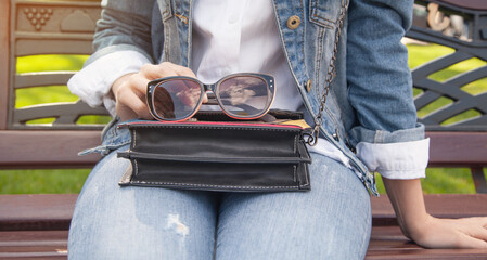 Wall Mural - Young woman holding sunglasses in outdoors.