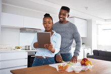 You Cant Go Wrong With A Step-by-step Recipe. Shot Of A Couple Looking At Something On A Digital Tablet While Cooking.