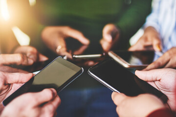 Canvas Print - Instantly connected. Cropped shot of a group of people using their phones together.