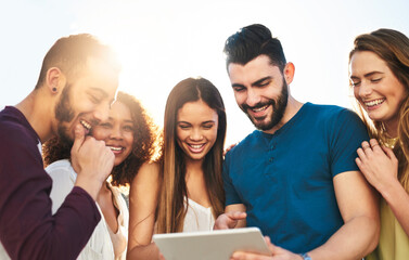 Aufkleber - Laughing at videos on the internet. Shot of young friends using a tablet outside.
