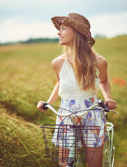 Sticker - Its a beautiful world, get out there and discover it. Shot of a young woman cycling through the countryside.