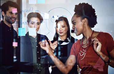 Canvas Print - Success is the plan. Cropped shot of a group of businesspeople working on a glass wall the office.