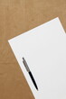 © Stanislav - Template of white paper with pen lies diagonally on light brown cloth background. Concept of business plan and strategy. Stock photo with empty space for text and design.