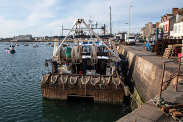 Wall Mural - Fishing boat moored on a quay in town