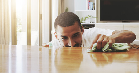 Aufkleber - I have to pay attention to detail. Shot of a focused young man cleaning the surface of a table with cleaning equipment at home during the day.
