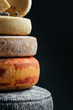 Various kind of cheese. head of handcrafted hard cheese on a dark background. vertical image. top view. place for text