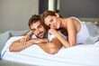 Going outside is so overrated. Shot of a happy young couple relaxing in bed together at home.