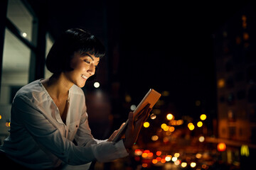 Poster - Staying in the know right through the night. Shot of an attractive young woman using a digital tablet outside in the city at night.