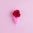 © ClareM - Rose and silicone menstrual cup on pink background. Women's periods concept. Square banner, selective focus, top view