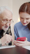 © iaginzburg - A woman shows her elderly father photos on her phone. They laugh and smile