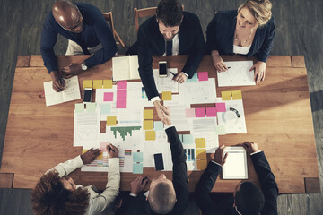 Poster - Starting new partnership is potential for success. High angle shot of a team of businesspeople working around a table in the office.