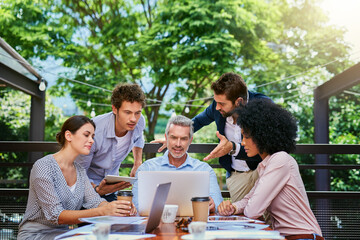 Proof that productivity can happen anywhere. Shot of a group of colleagues having a meeting at a cafe.