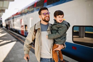 Happy family, father and his son, are waiting for train in subway.