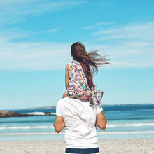 The View Is Better From Daddys Shoulders. Rearview Shot Of A Young Father And His Daughter Enjoying A Day At The Beach.