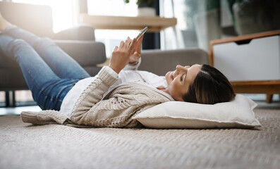 Poster - Meeting new people online. Shot of a beautiful young woman using her cellphone while relaxing at home.