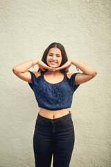 Wall Mural - Happiness is something you have to create for yourself. Portrait of a happy teenage girl posing against a wall outside.