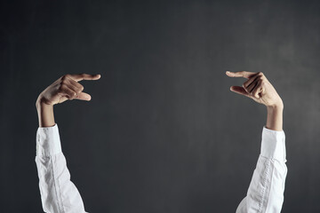 Poster - Check this out. Shot of hands pointing to each other against a dark background.