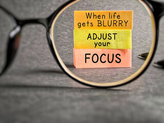 Wall Mural - Inspirational and motivational quote. When life gets blurry, adjust your focus. Text written on notepaper background.