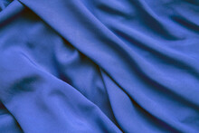 Background From Blue Fabric In Folds. The Texture Of The Fabric.