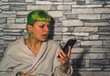 Mujer gritándole al teléfono móvil, chica de pelo verde enfadada dando voces , el estrés en el teletrabajo en la nueva normalidad