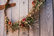 Close Up Photo, Part Of Twisted Crafting, Natural Creative Dry Herbal Wreath From Twigs Of Wild Flowers, Cereal And Grass. Traditional Festive Ethnic Decoration On Entrance Door. Thanksgiving Day