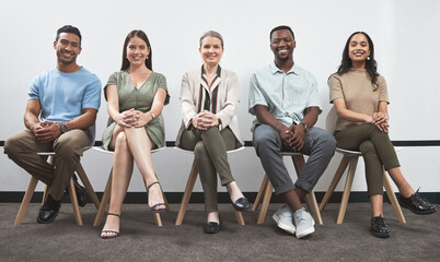 Poster - Confident and keen to prove their talent. Portrait of a group of businesspeople sitting together in a line against a white wall.