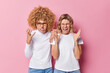 © wayhome.studio  - Irritated two young women friends gesture angrily feel annoyed exclaim loudly bothered with too loud sound wear white clothes isolated over pink background. People and negative emotions concept