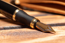 Fountain Pen, Beautiful Fountain Pen In An Environment With An Old Clock, Old Book, Ink Among Others, Selective Focus.