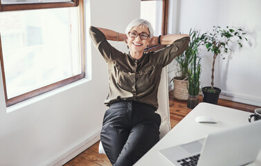 Aufkleber - I crush deadlines. High angle portrait of an attractive mature businesswoman sitting with her hands behind her head in the office.